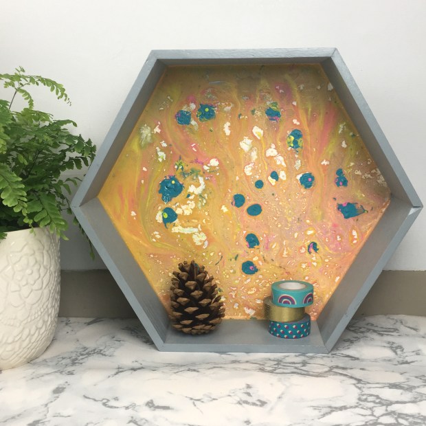 front shot of finished shelf with plant, pinecone and washi tape