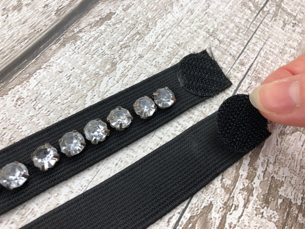 Ladies hand sticking velcro dot onto black elastic